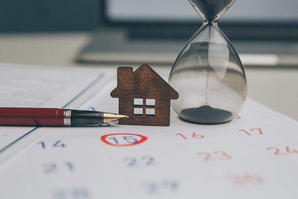 House and sand timer sat on a calendar with a circled eviction date